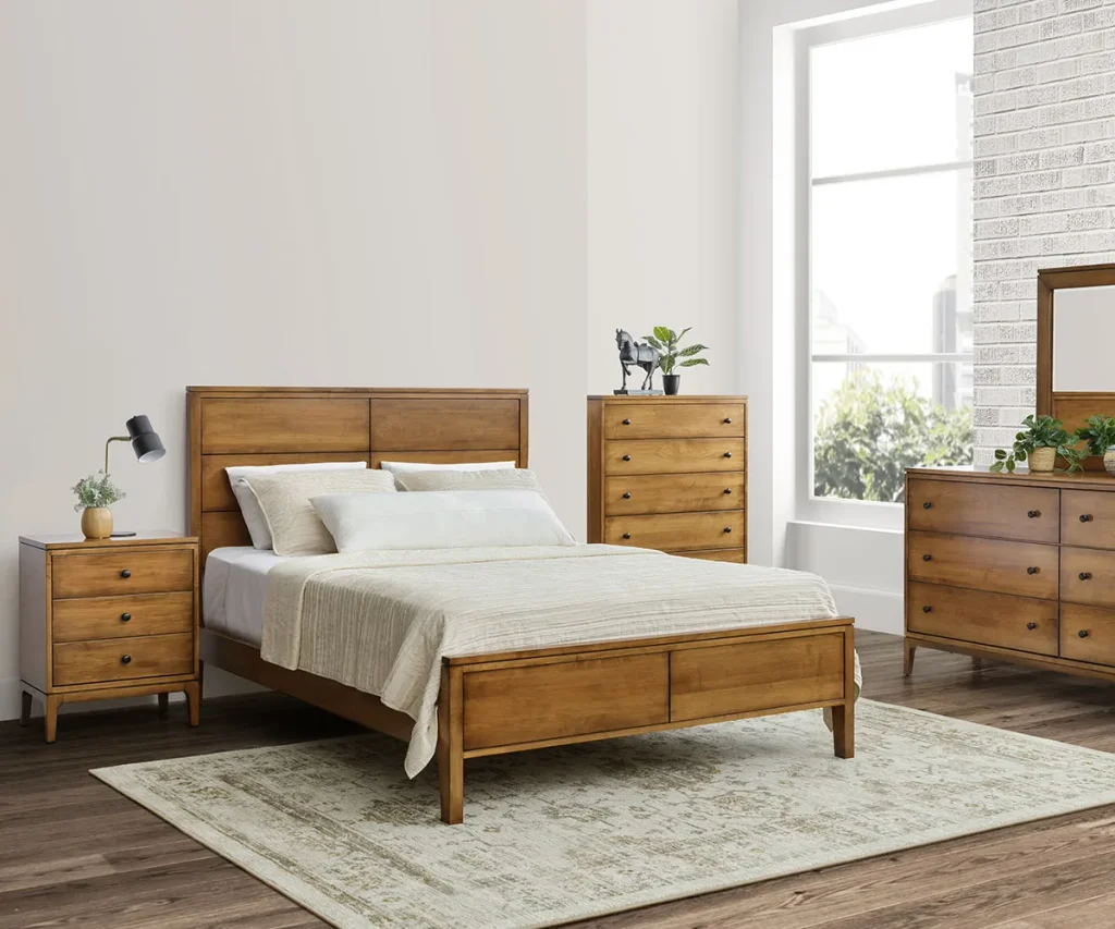 Solid wood bedroom set with a wooden bed, nightstand, chest, and dresser in a bright bedroom.