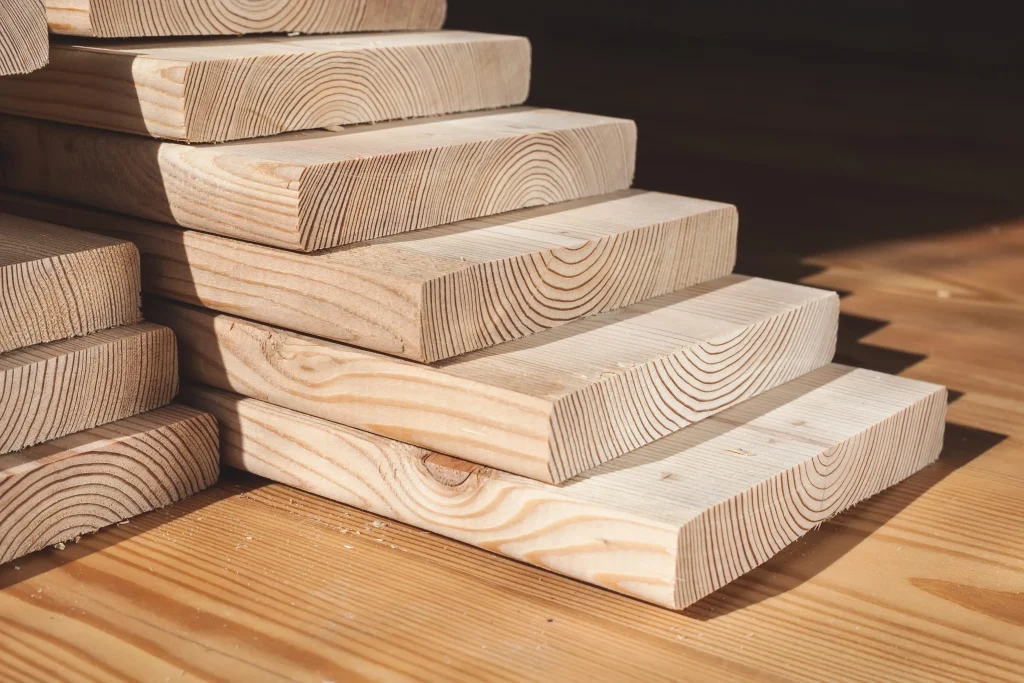 Stacked solid wood boards showing natural grain patterns and wood construction.
